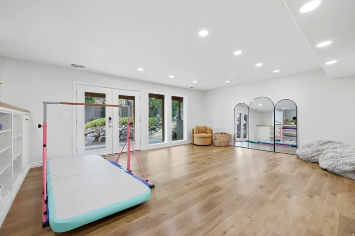 Spacious room featuring wood-finish flooring, recessed lighting, and white walls