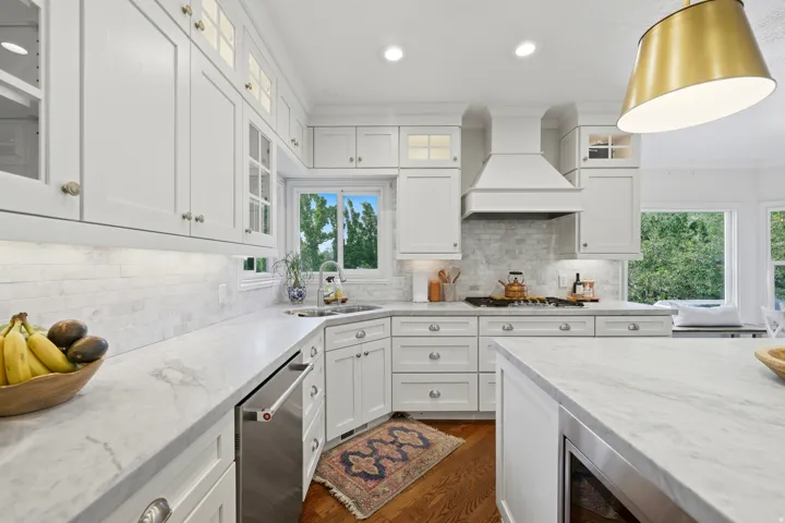White shaker cabinetry with glass-front accents and under-cabinet lighting