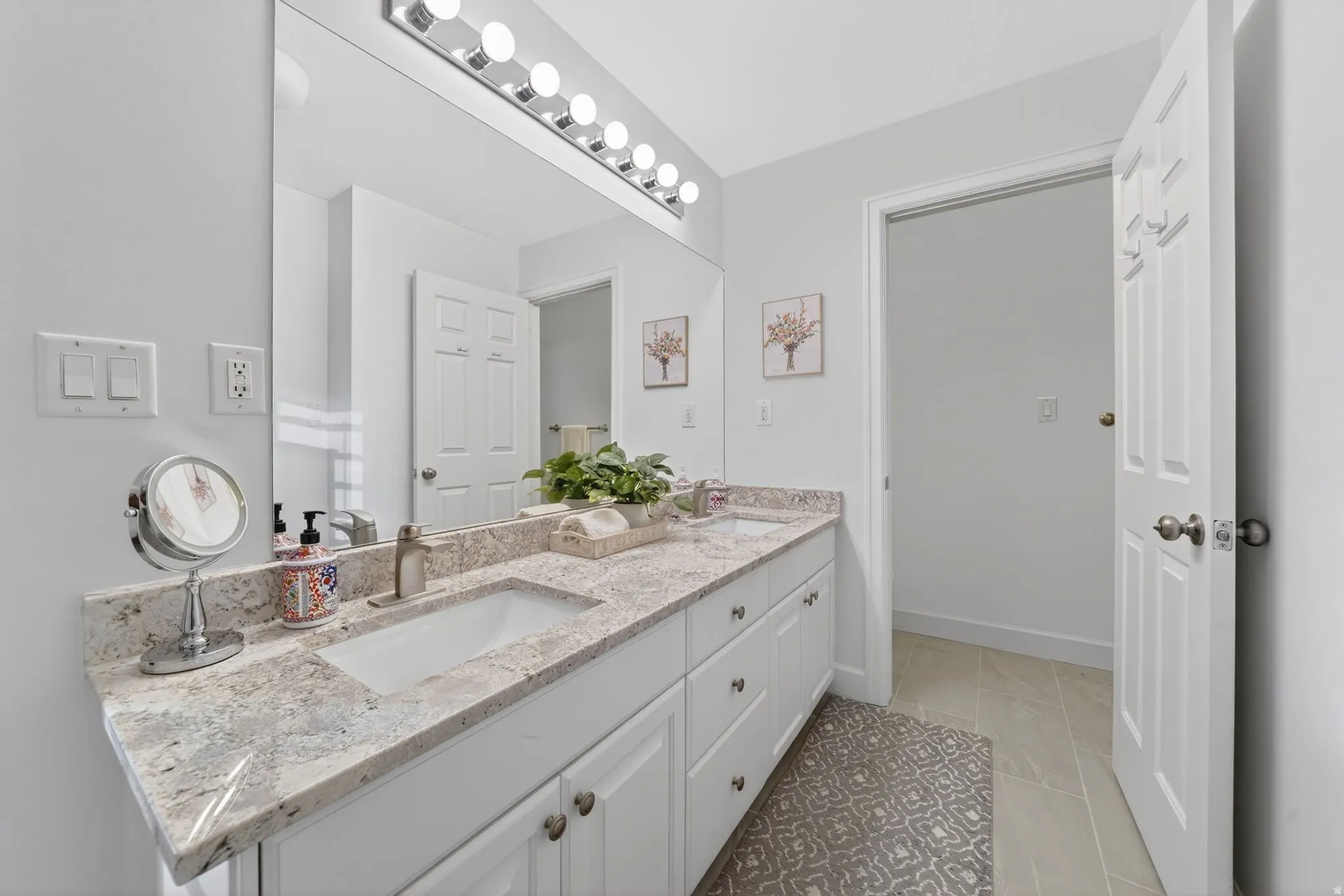 Double vanity featuring integrated sinks, light-toned countertops, and white cabinetry