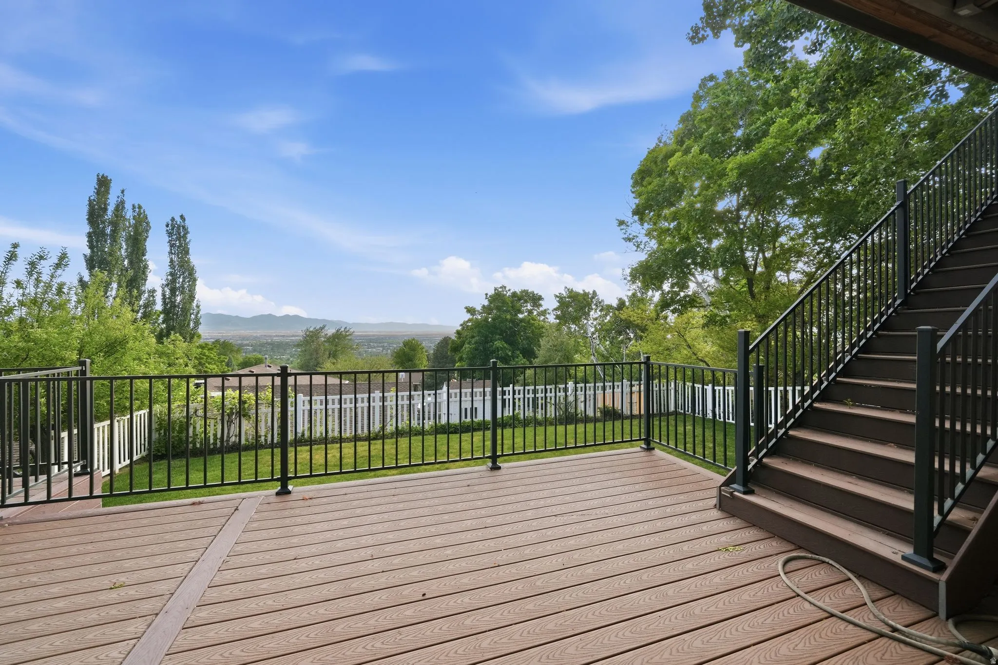 Expansive composite deck featuring black metal railings and a staircase