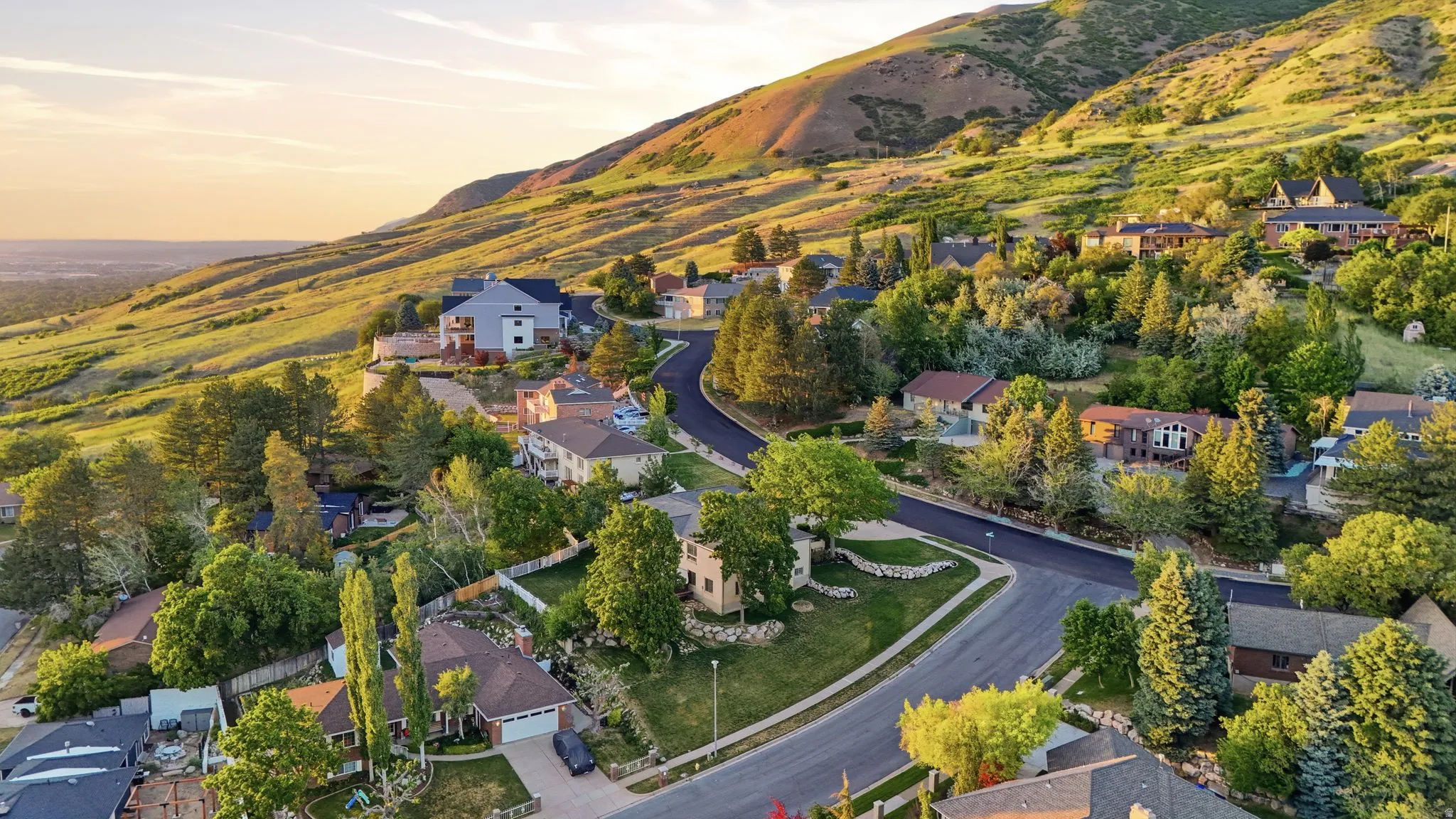 Nestled on a verdant hillside, this property features a paved cul-de-sac and mature trees