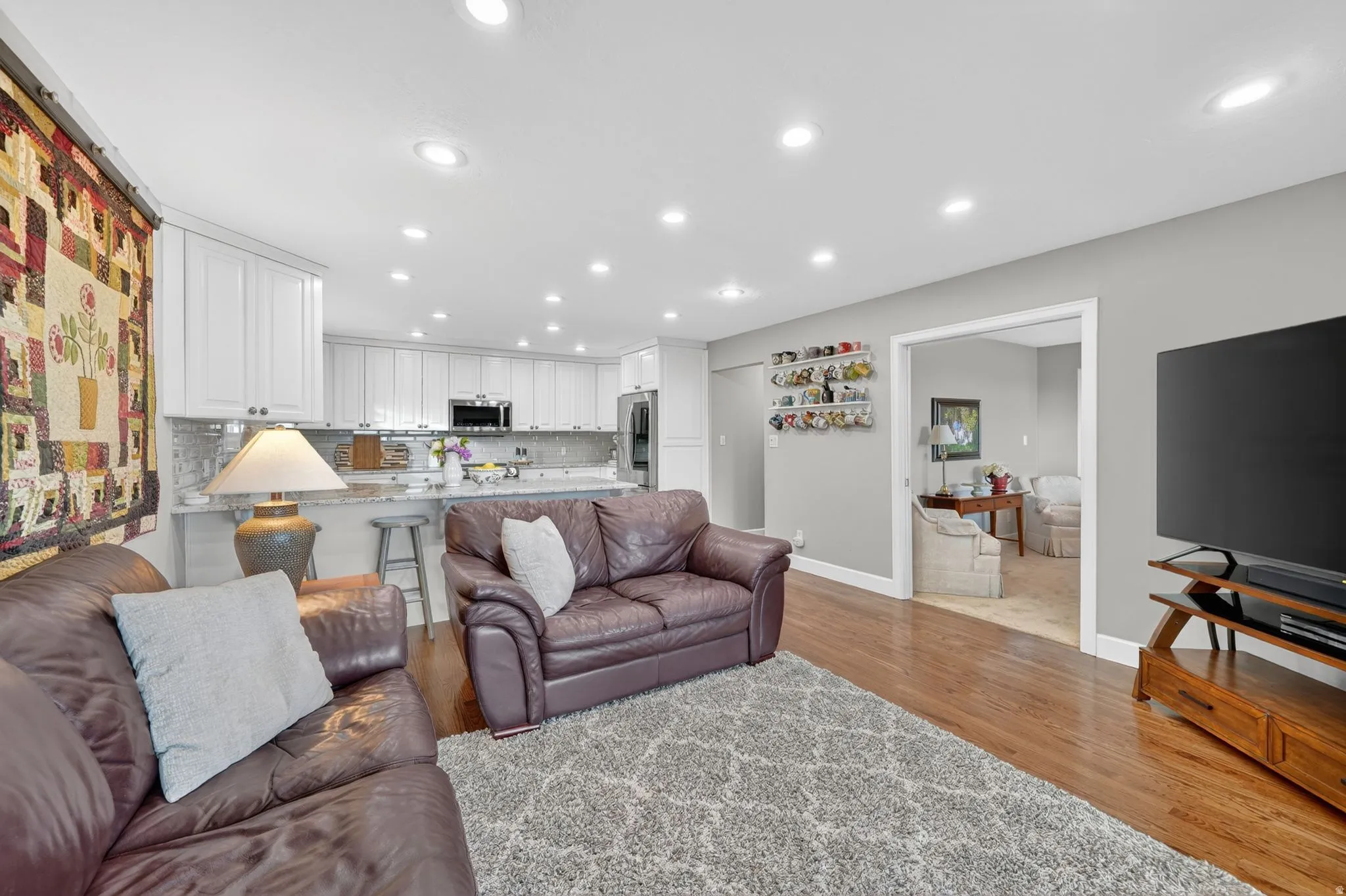 Open-concept living space featuring wood-finish flooring, recessed lighting, and light gray wall paint