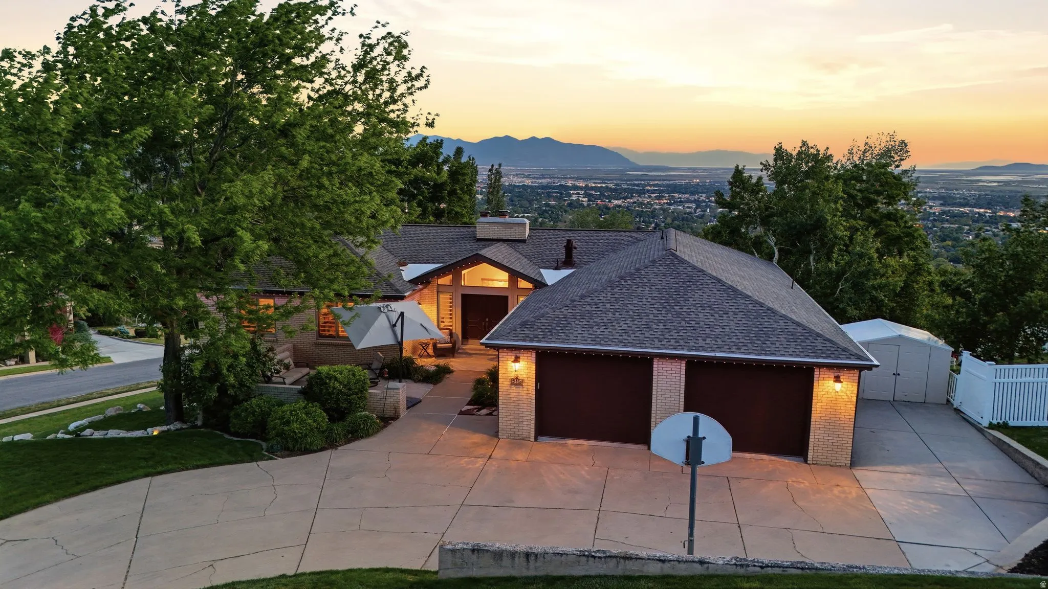 Expansive paved driveway leading to a two-car garage with brick accents