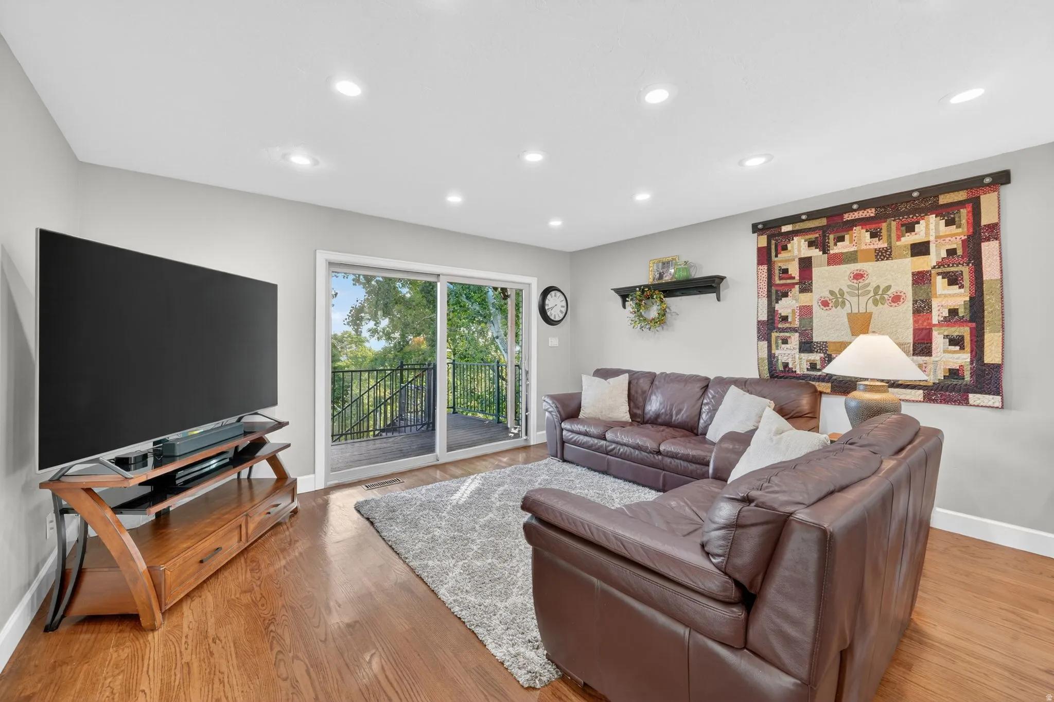 Living space featuring a sliding glass door to an outdoor deck, recessed lighting, wood-finish flooring, and light gray wall paint