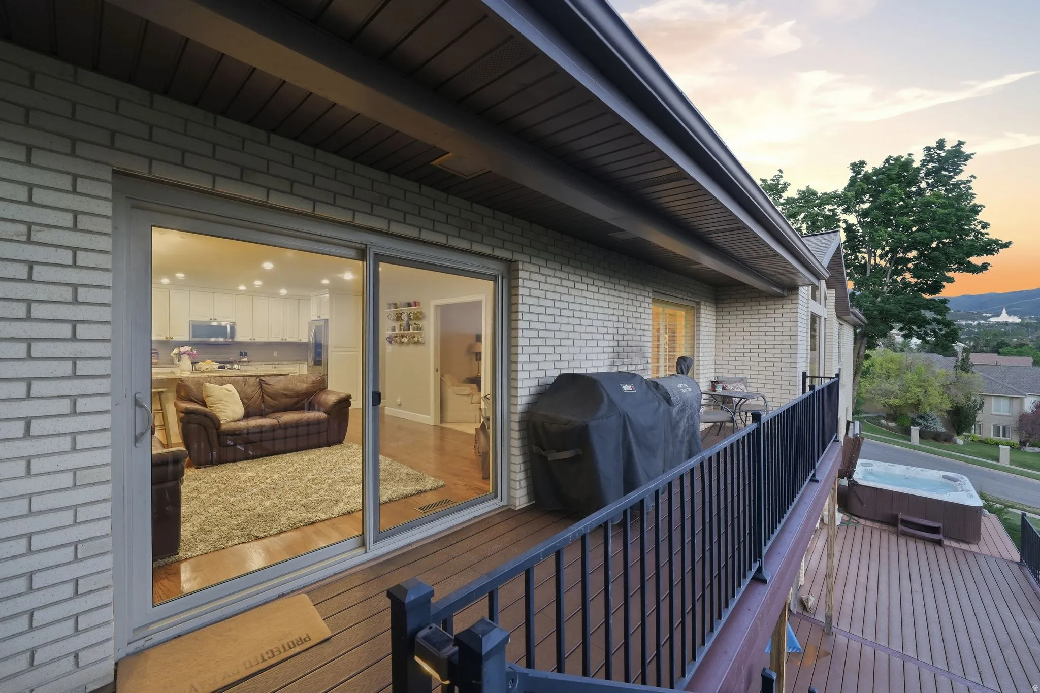 Expansive deck featuring wood-finish decking, black metal railings, and a built-in spa