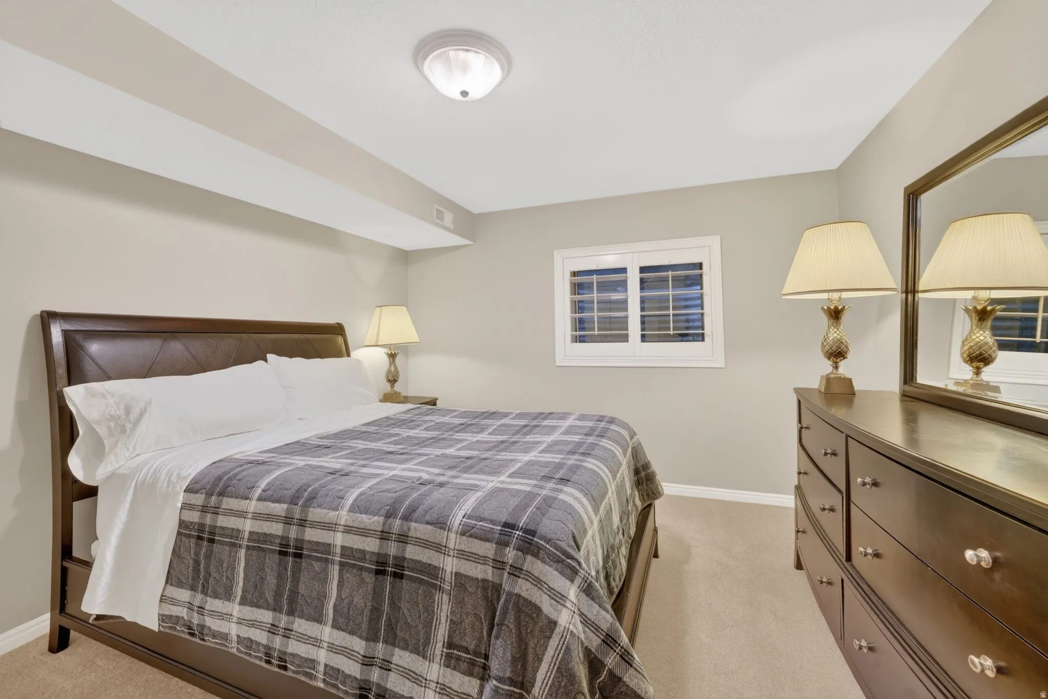 Carpeted room with neutral wall color and ceiling light fixture