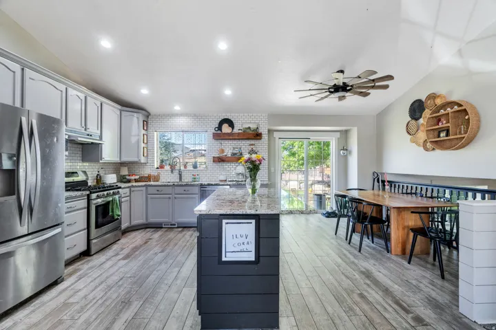 Kitchen featuring light gray cabinetry, stainless steel appliances, and wood-finish flooring
