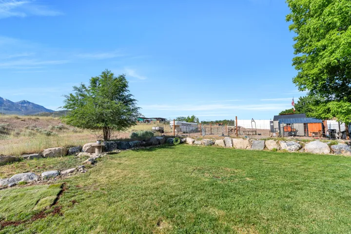 Expansive green lawn with a natural stone retaining wall