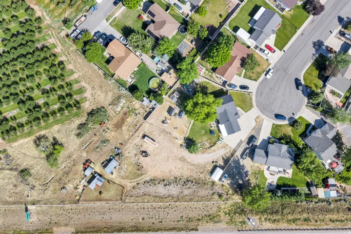 Aerial perspective showcasing a property with significant undeveloped land, situated at the edge of a residential cul-de-sac