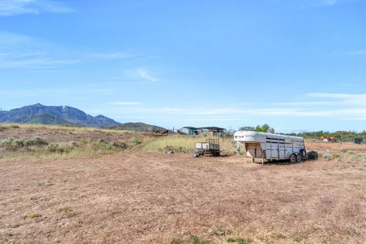 Expansive open land featuring distant mountains, a clear sky, and a gentle slope