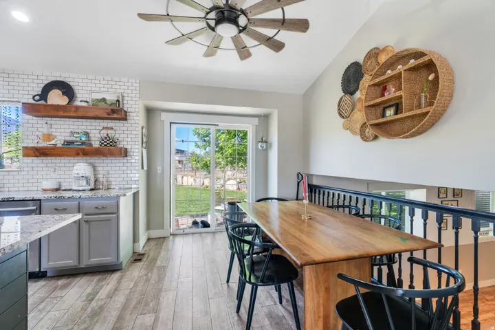 Open dining area featuring a wood-finish table and a black spindle railing