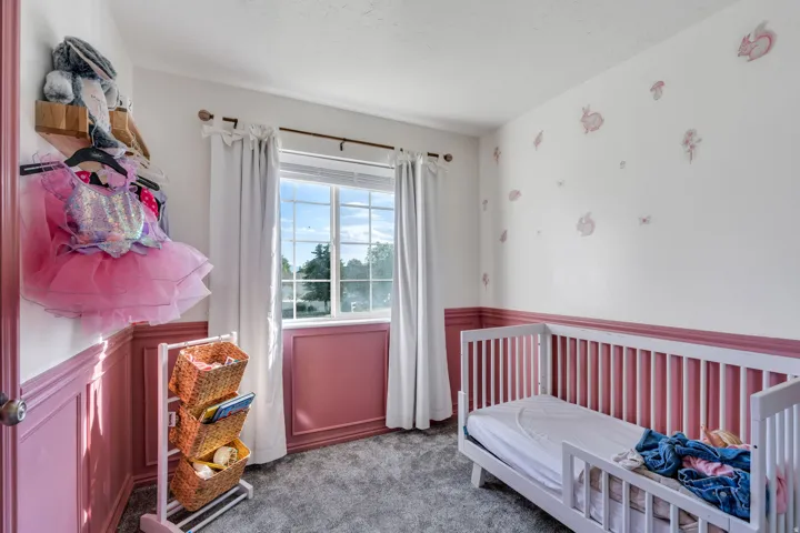 Interior room featuring a window with white blinds, white trim, and white curtains