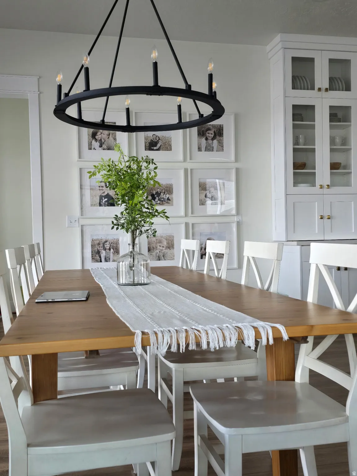Dining space featuring a large natural wood-finish table and a circular black chandelier