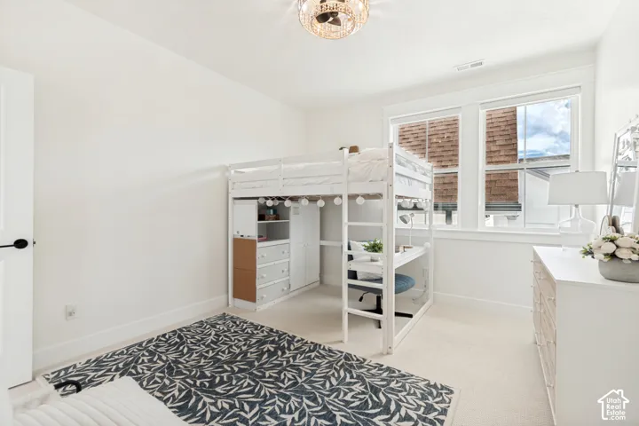 Bright room featuring a crystal chandelier and light-colored carpeting