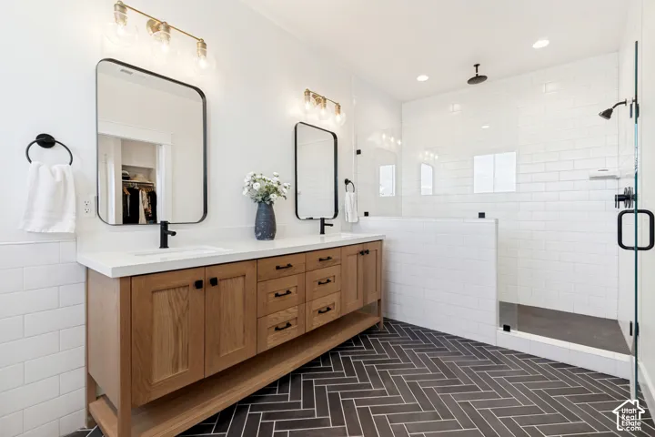 Bathroom featuring a double vanity with wood-finish cabinetry, white countertop, and rectangular undermount sinks
