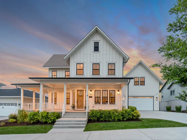 Modern farmhouse-style residence featuring white vertical siding and a dark shingle roof
