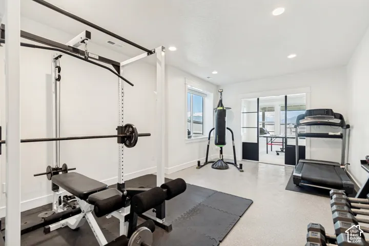 Dedicated fitness space featuring light-colored flooring and recessed lighting