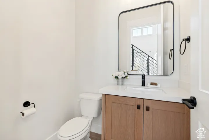 Modern vanity with a light wood-finish base, integrated rectangular sink, and white countertop