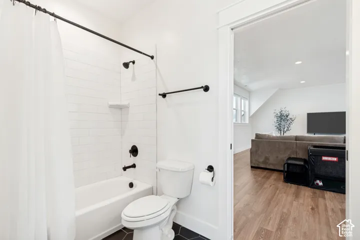 Guest loft bathroom featuring a white subway tile shower surround, matte black fixtures, and hexagonal floor tiles