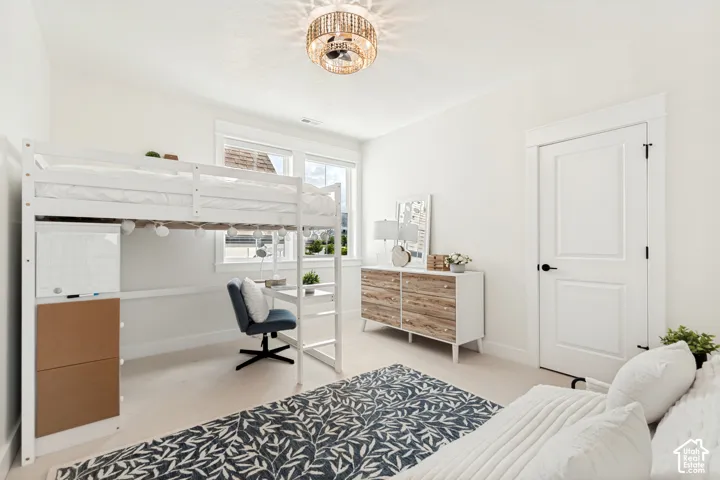 Bright room featuring light-colored carpeting, white walls, and a multi-pane window