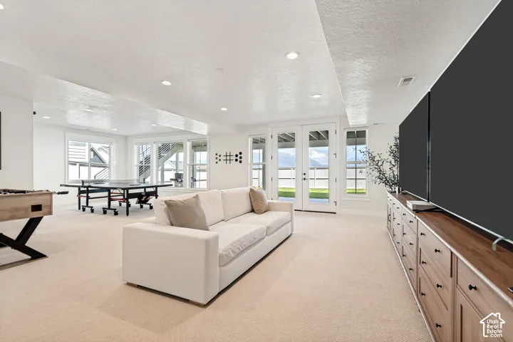 Spacious lower-level area with light-colored carpeting and recessed lighting