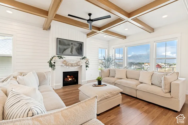 The family room features tasteful finishes including an inviting fireplace, coffered ceiling with wood beams, and a custom accent wall.