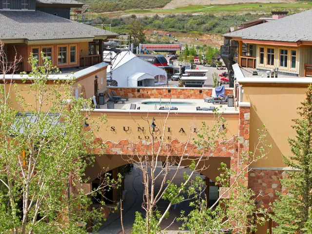 Lodge exterior featuring varied stone and stucco finishes, an arched entryway, and a rooftop spa