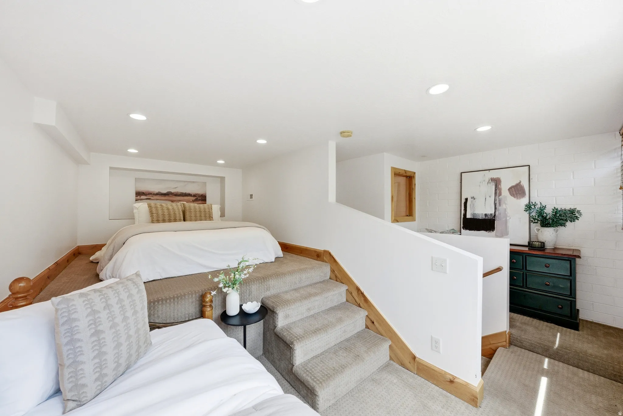 Multi-level room with recessed lighting, platform sleeping area, and wood-finish trim
