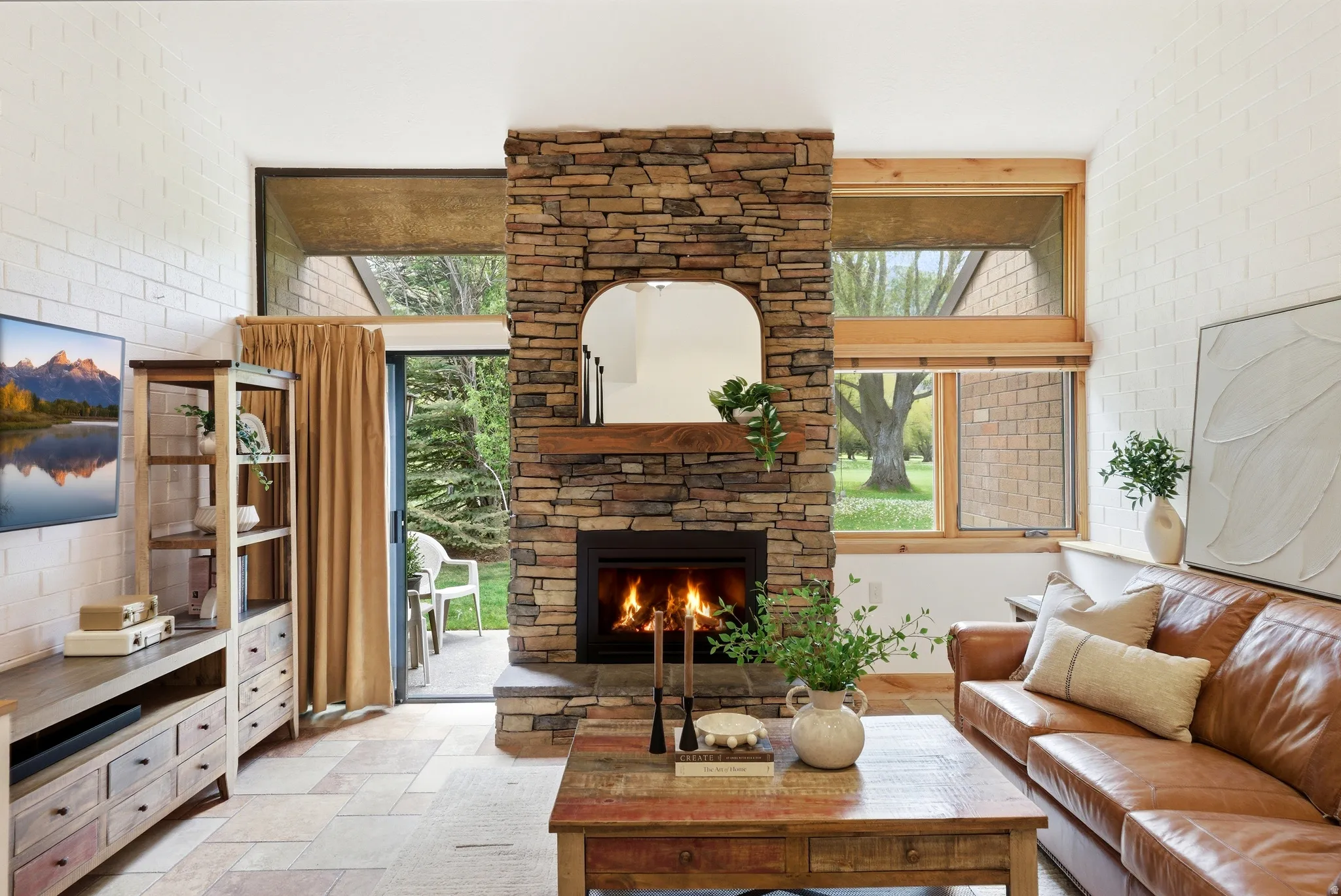 Stacked stone fireplace with a wood mantle and stone hearth