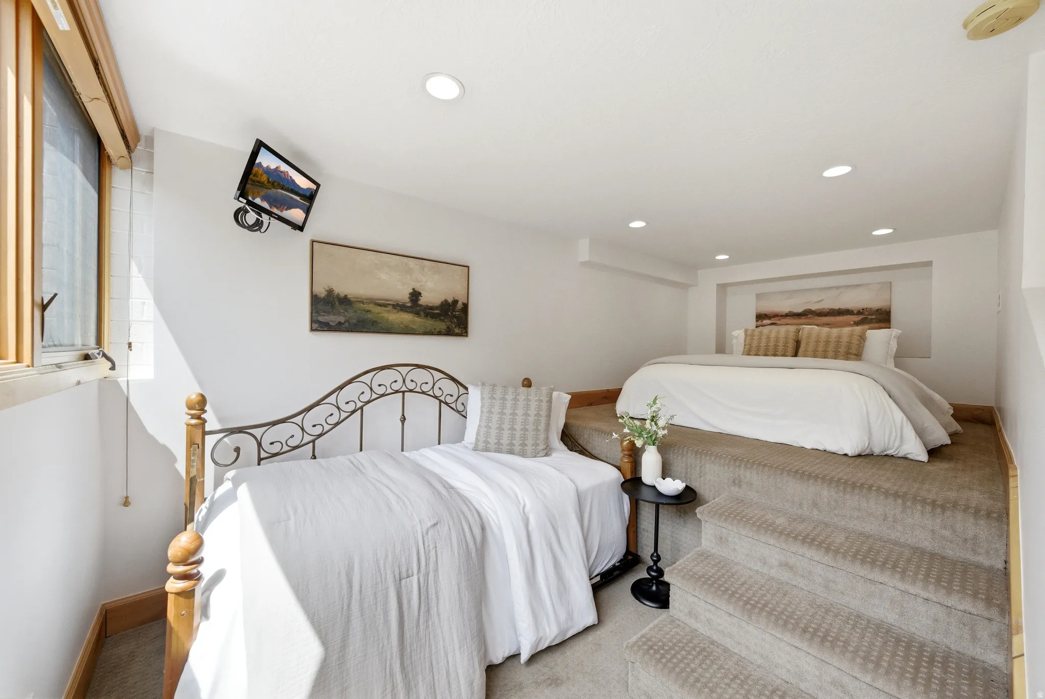 Carpeted split-level room featuring recessed lighting, a raised platform, and a built-in bed nook