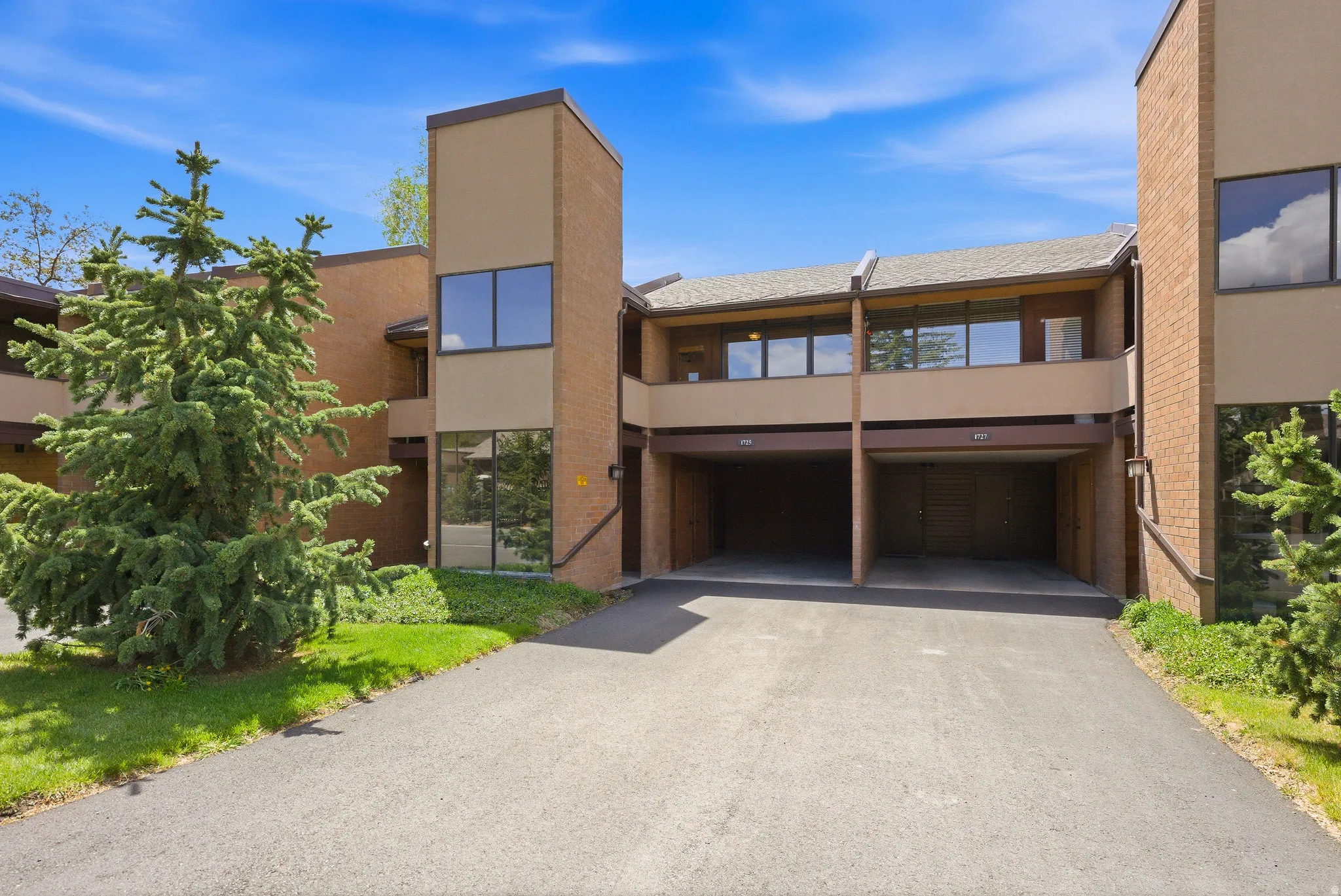 Multi-level residential facade featuring brick and stucco elements