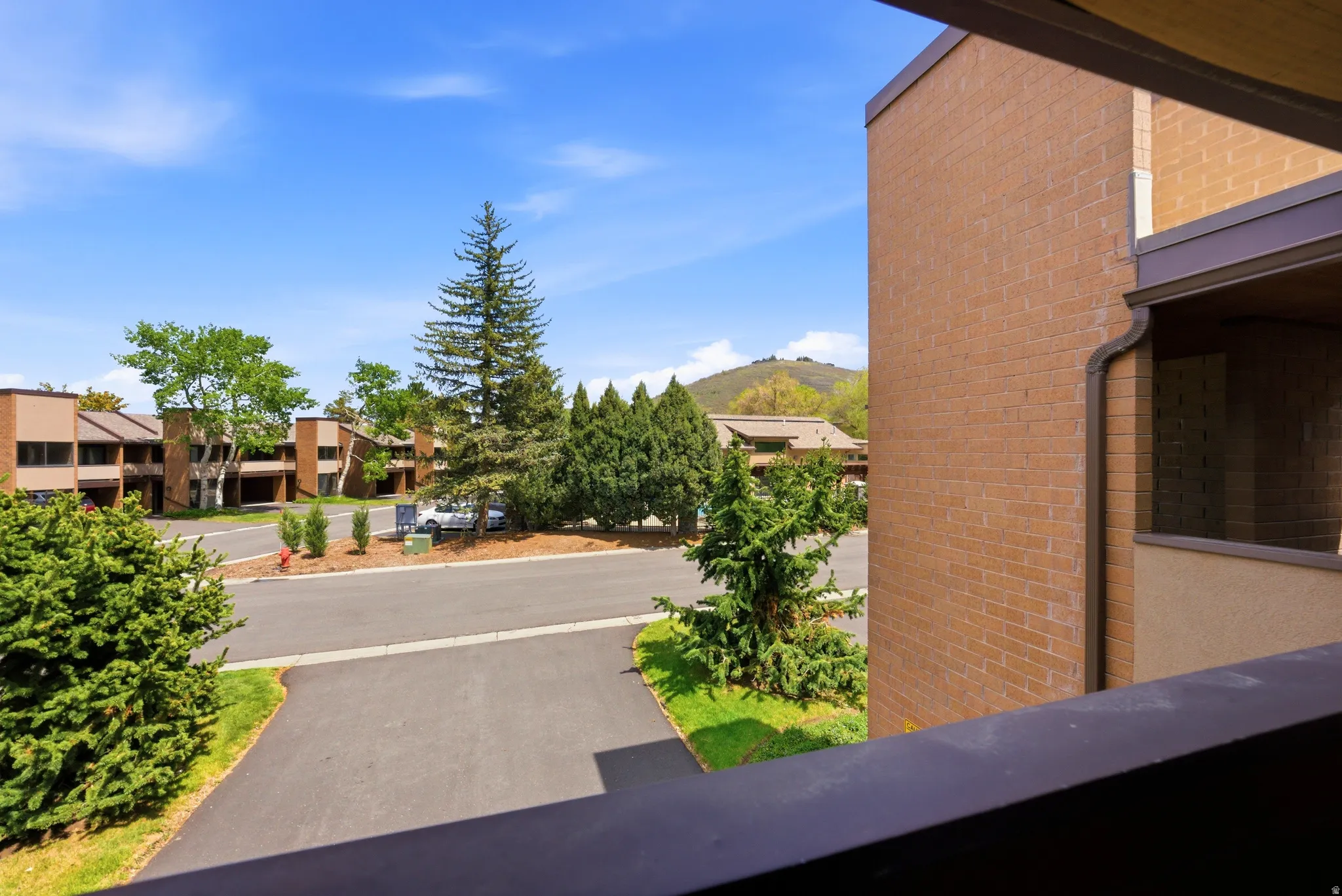 Brick exterior with dark trim and a substantial balcony