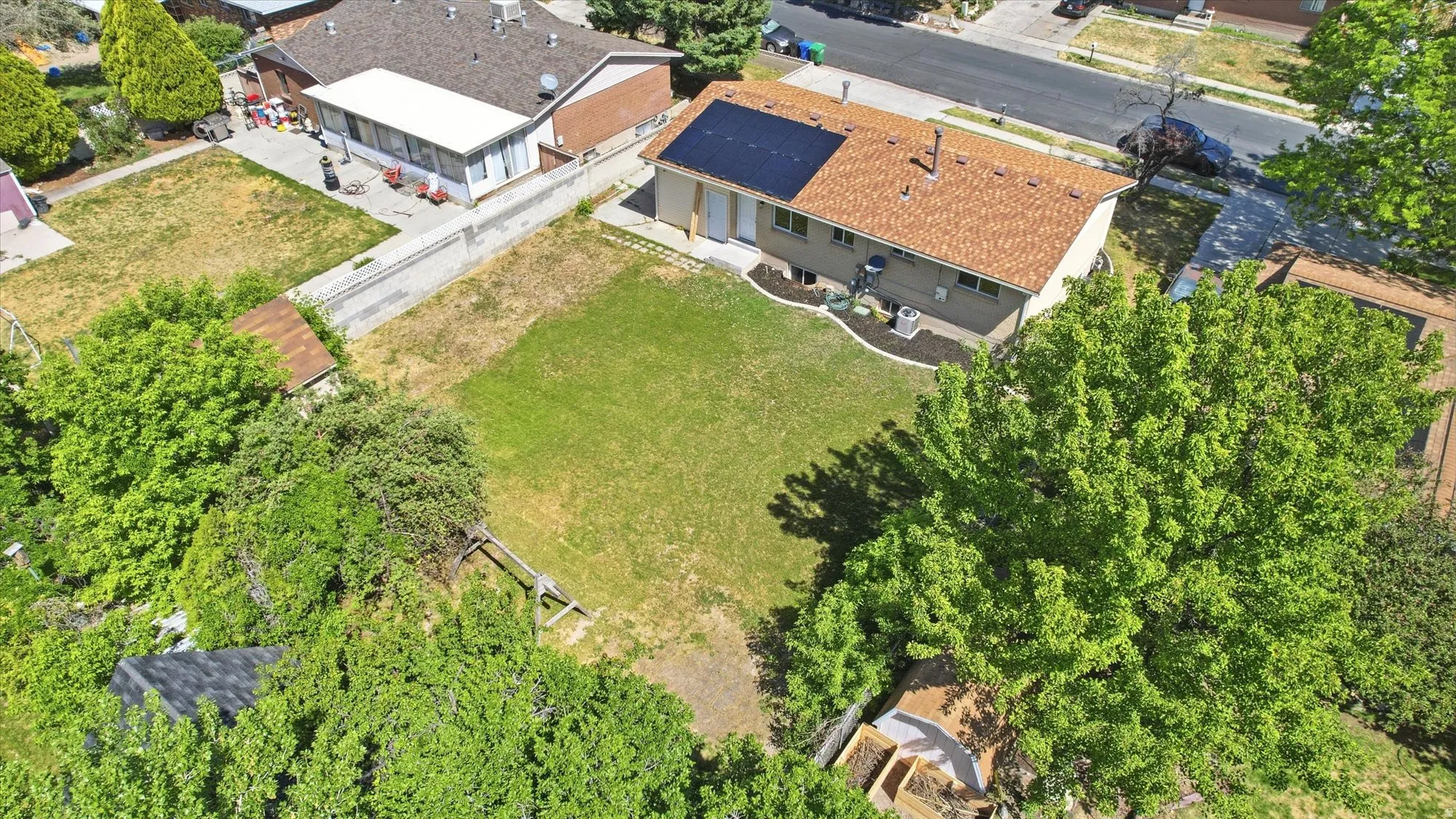 Single-story residence featuring a brown shingle roof, solar panels, and a neutral-toned exterior