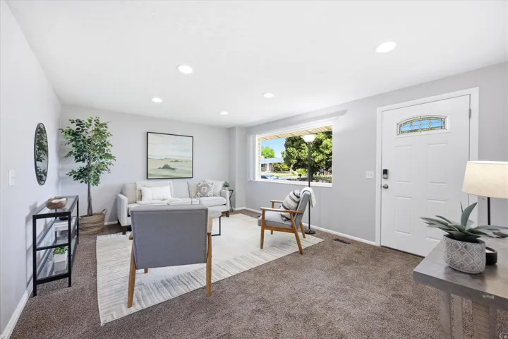 Living area featuring recessed lighting, a large window, and light gray walls