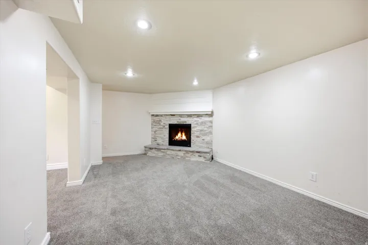 Living area featuring a corner fireplace with stacked stone surround and hearth