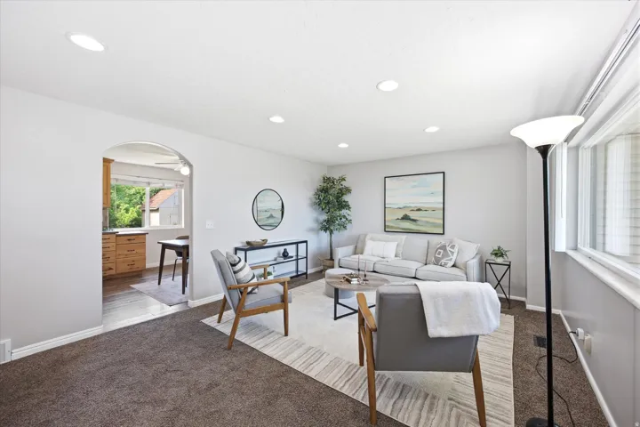 Living area featuring recessed lighting, light gray wall paint, and a large window with blinds