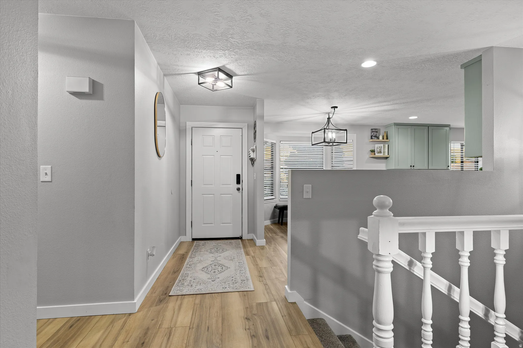 Stairway to the Finished Basement. Bright entryway with wood-finish flooring
