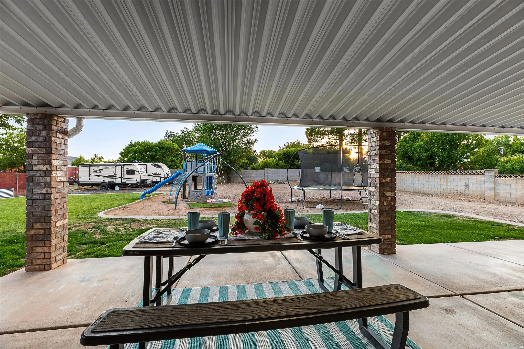 Covered Back Patio with Backyard Views. Covered patio area featuring a metal roof and brick columns