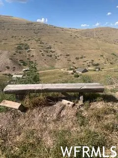 Rustic wooden bench overlooking a vast, rugged landscape with distant structures