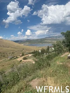 Expansive hillside terrain with distant water body
