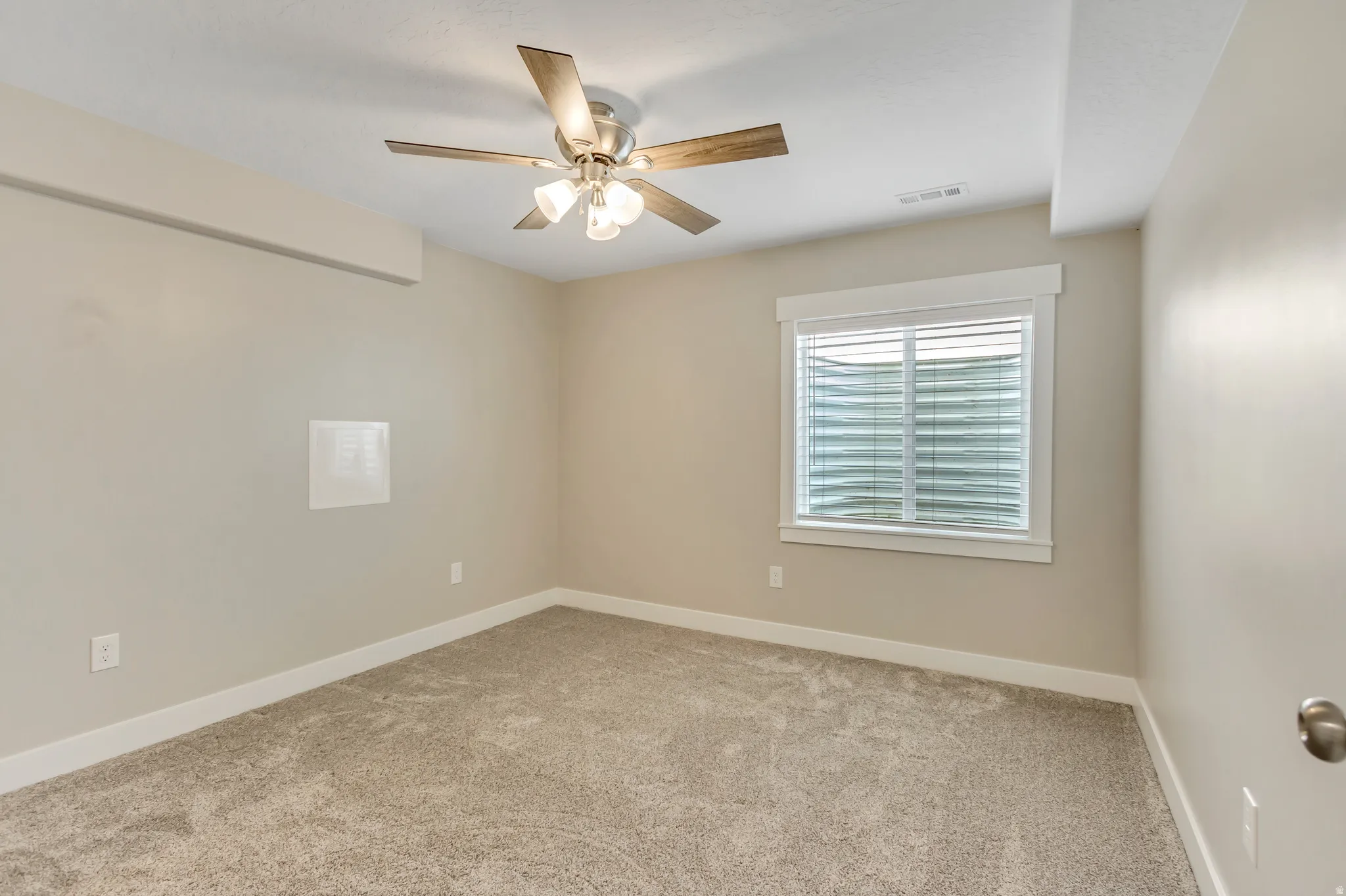 Fifth bedroom in this home has neutral-toned walls that complement plush carpeting