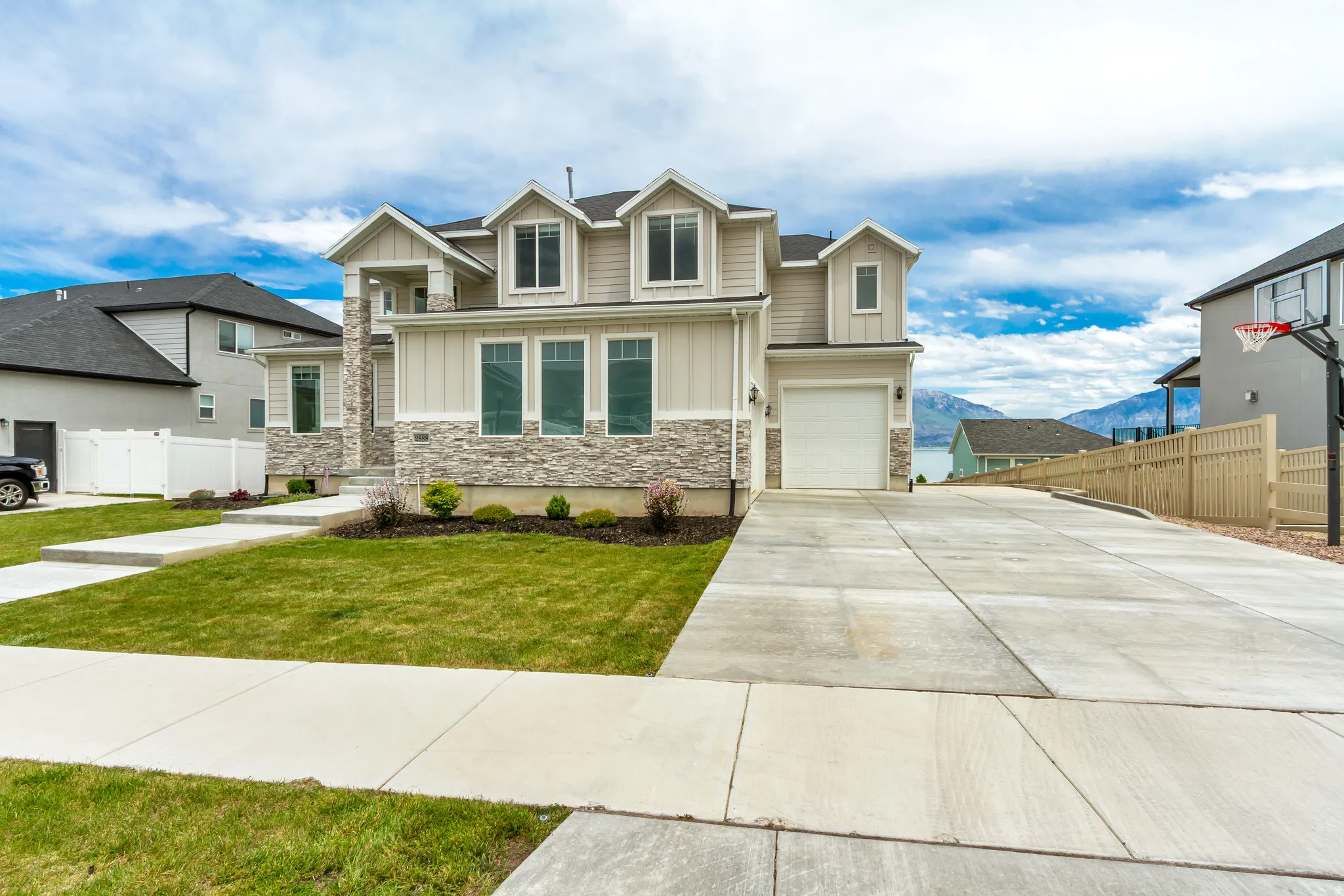 Contemporary two-story home featuring light siding and stone veneer accents