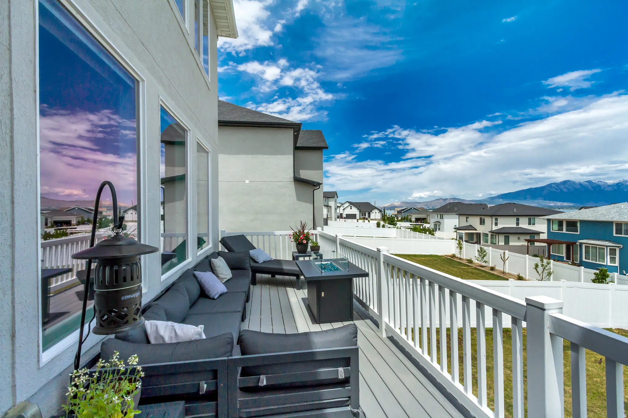 Upper-level deck featuring composite decking and white railing, offering elevated outdoor living.