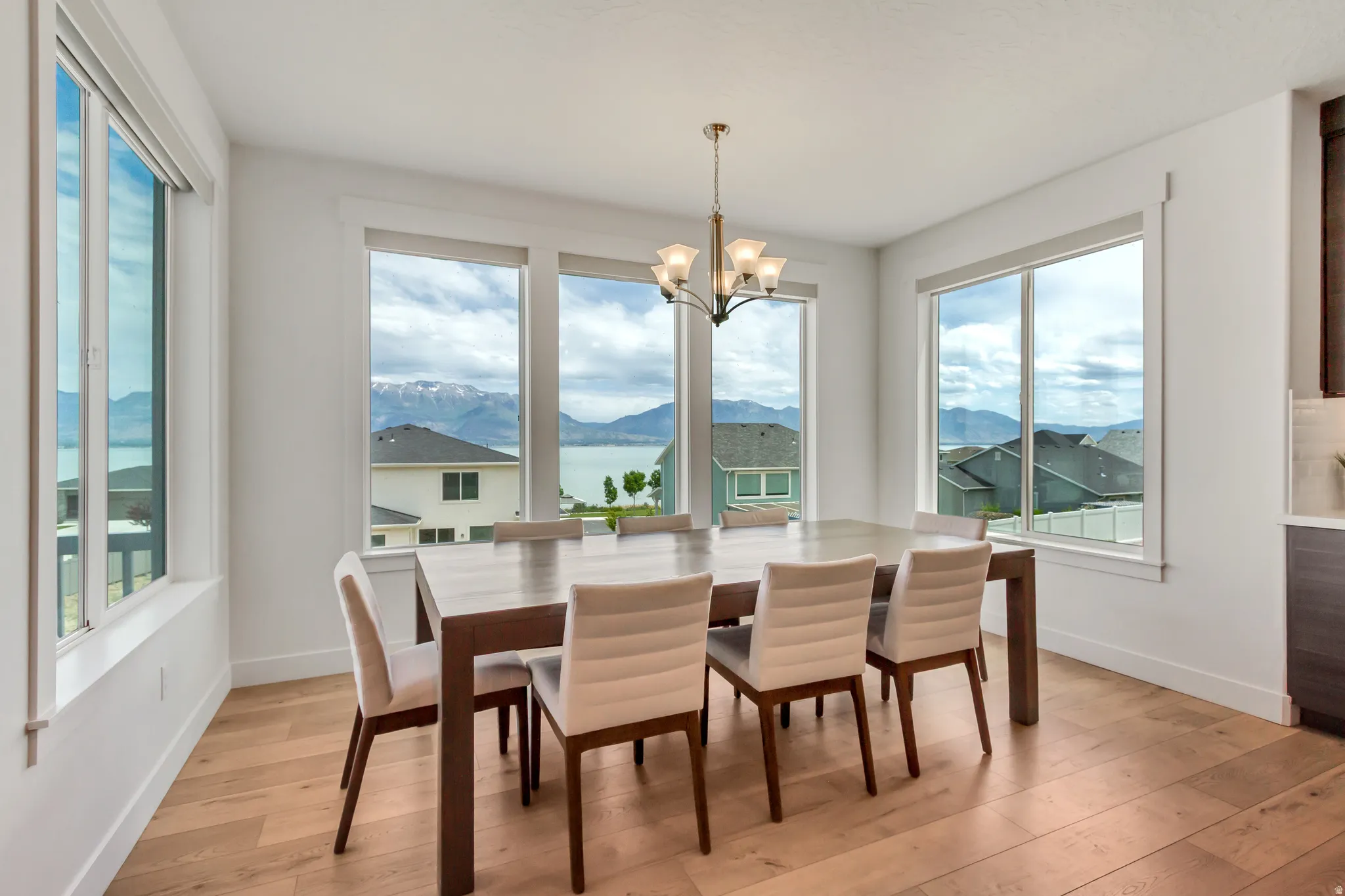 Dining area featuring multiple large windows, wood-finish flooring, and a multi-light chandelier