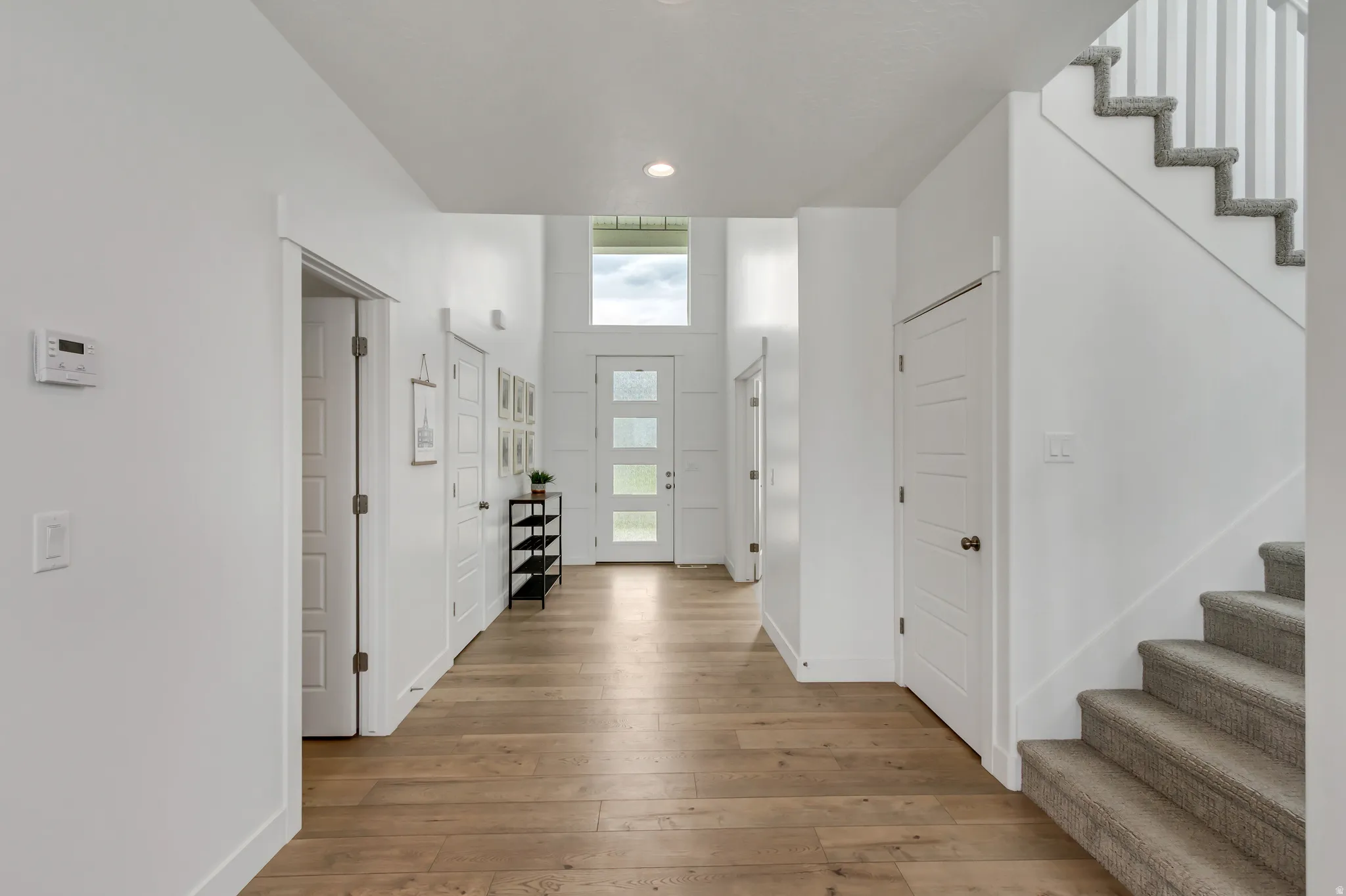Bright entry foyer featuring wood-finish flooring