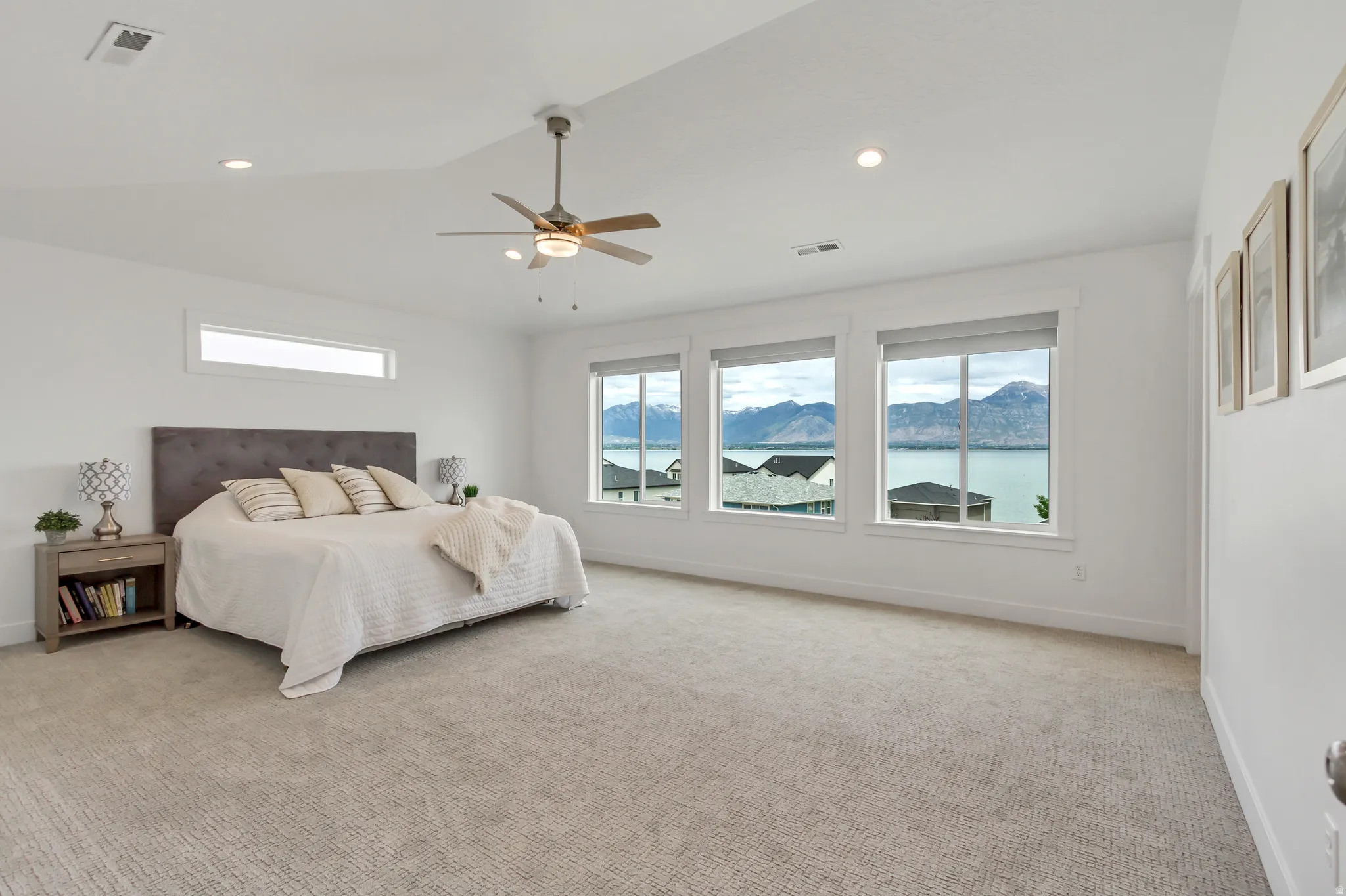Spacious primary bedroom with stunning views featuring a high vaulted ceiling with a ceiling fan, recessed lighting, and multiple windows