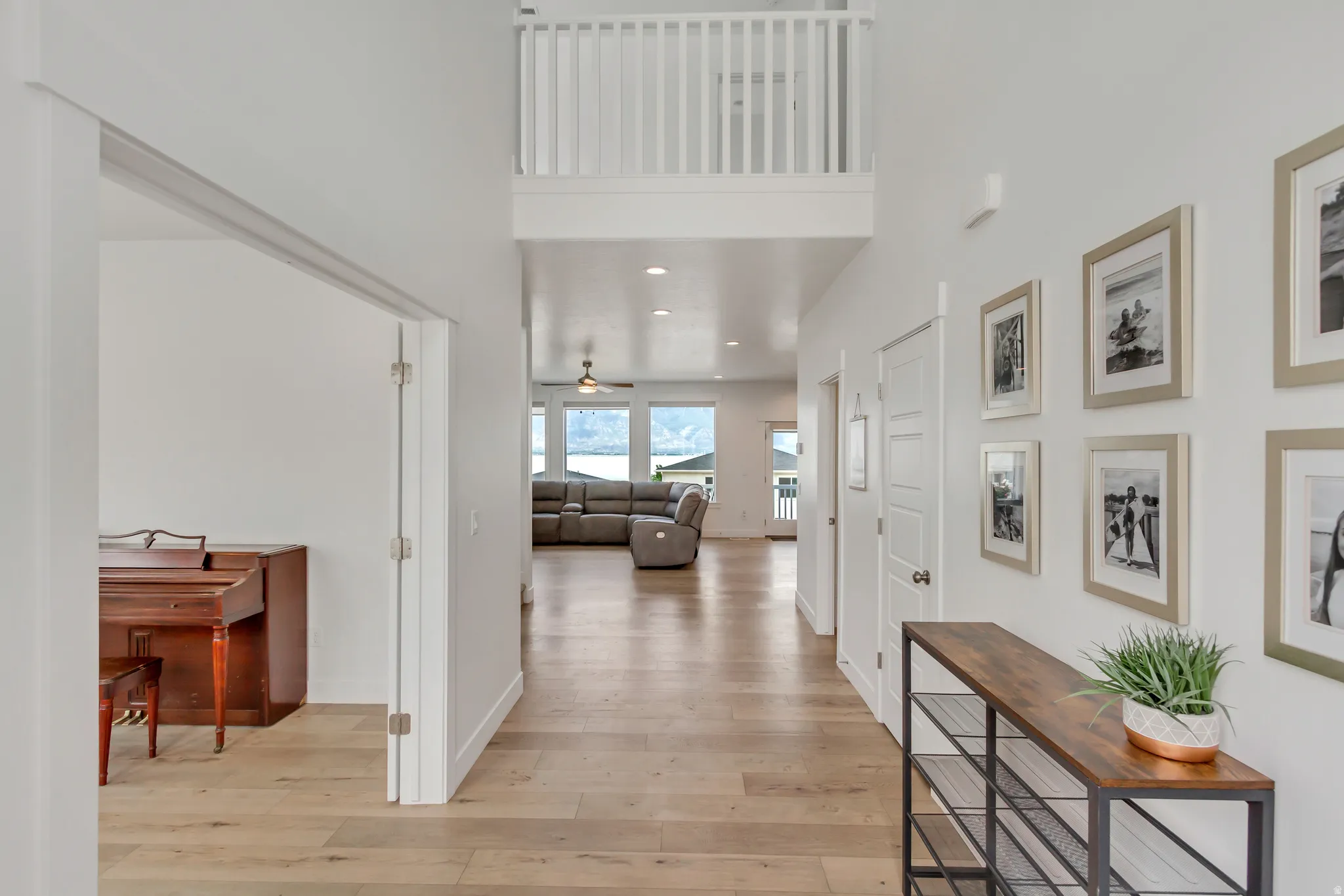 Two-story entryway featuring wood-finish flooring, a white balustrade overlooking the space, and recessed lighting