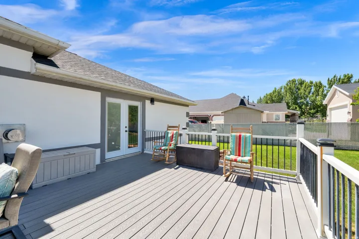 Expansive deck with composite wood-finish decking and white railings featuring black balusters