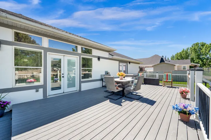 Spacious composite deck with white and black railings, offering direct access to the interior through double glass doors