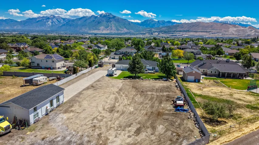 Expansive cleared lot with a partially paved driveway
